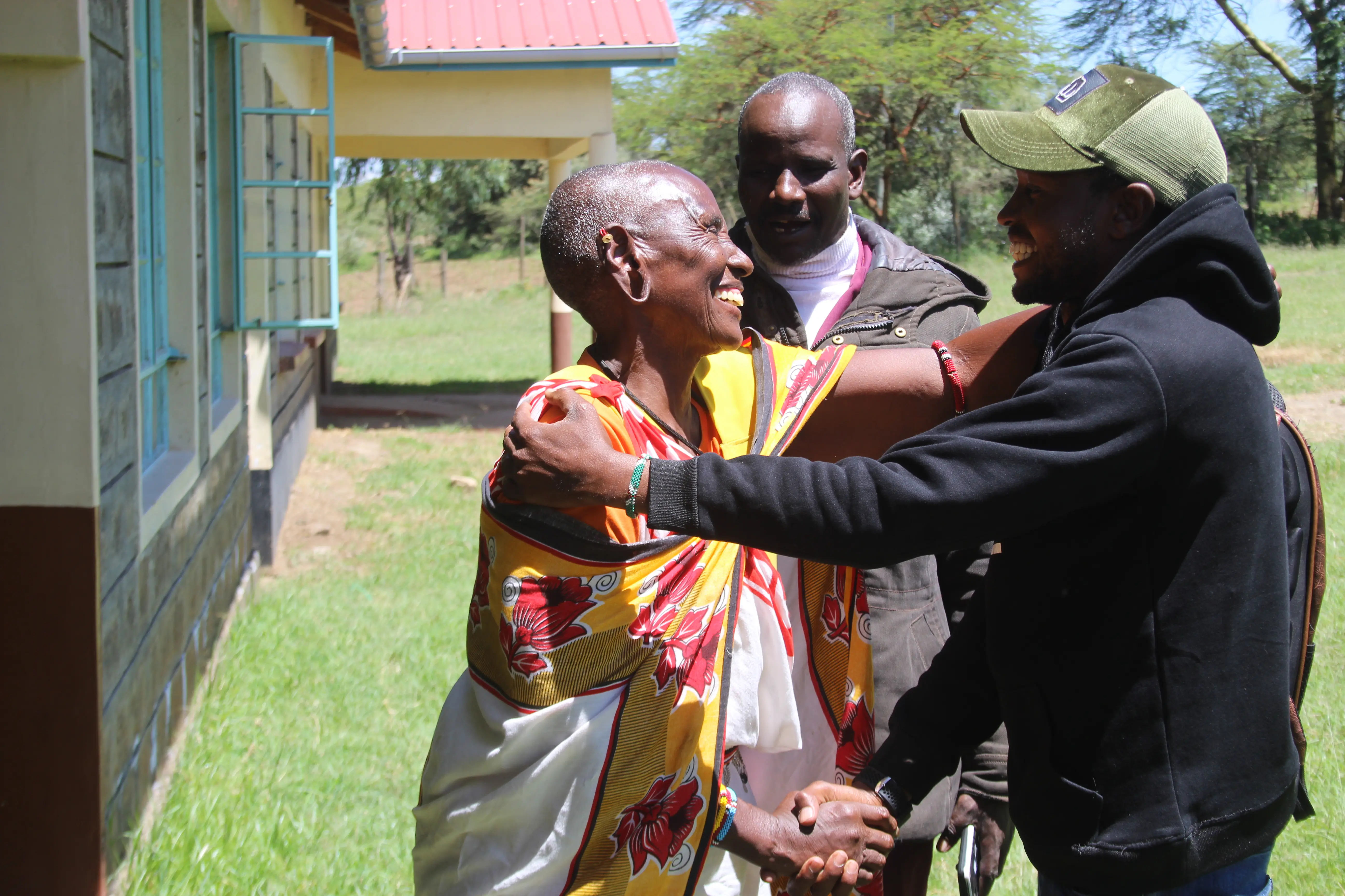 Mama Pauline Parkei shake hands of his youngest son Milton Parkei as his elder son observes